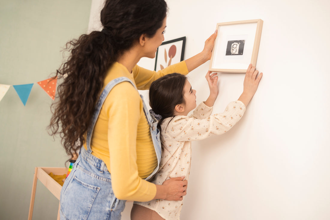 mother and child hanging up framed picture of an ultrasound